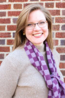 photo of author in neutral shirt and purple scarf