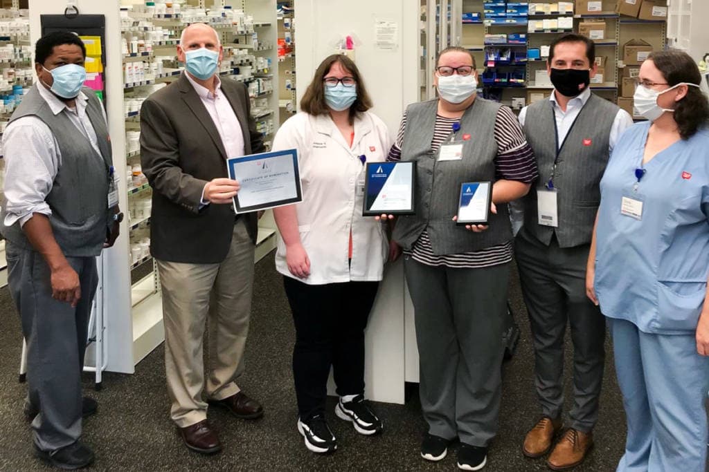 employees at walgreens posing with awards certificates
