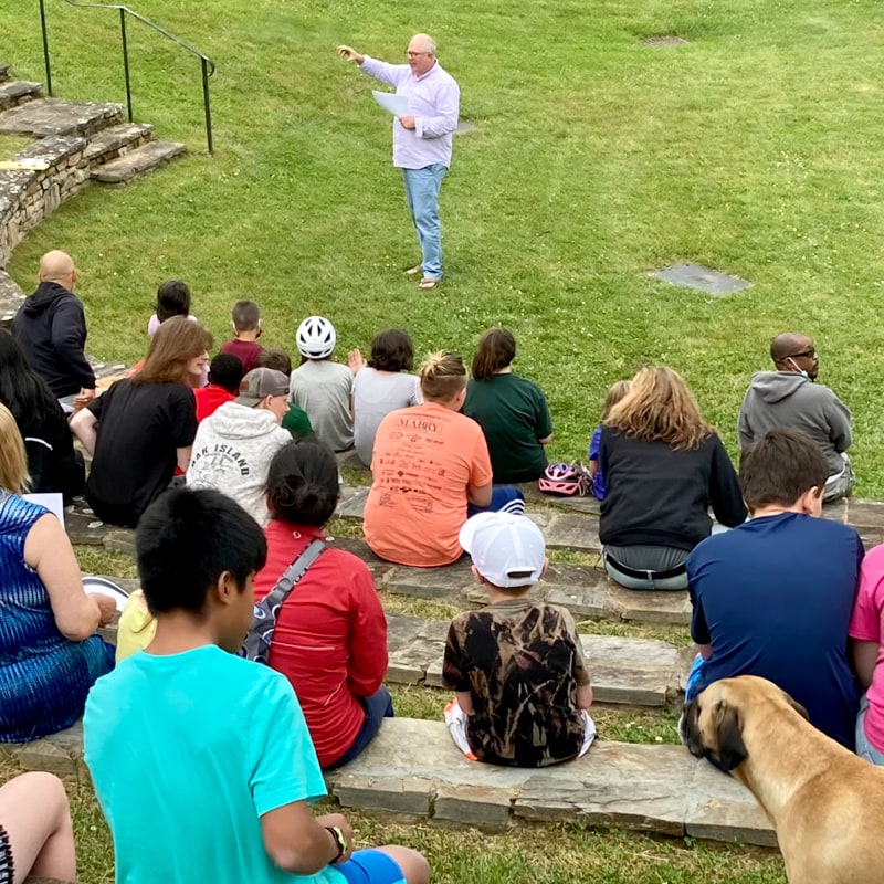 pastor speaks to a group of kids in an outdoor amphitheater on Crossnore's campus