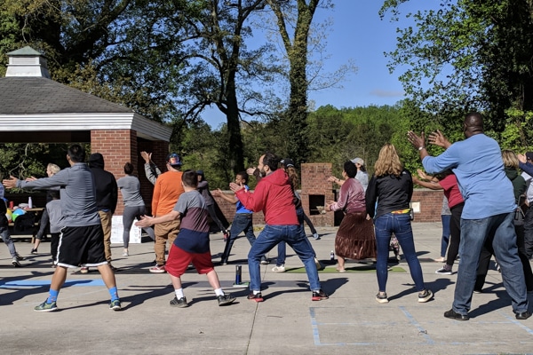 group of counselors and children from behind doing tai chi