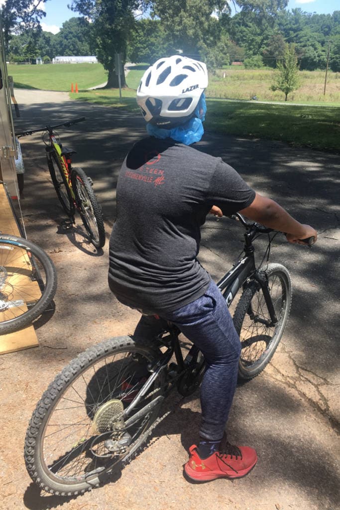 teen boy sits on bike looking away from camera