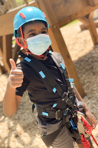 a little boy, jody, with a ropes course harness 
