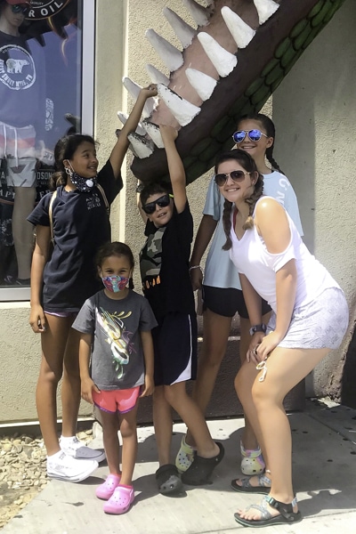 five of the siblings at a beach store under the teeth of a fake alligator's giant mouth