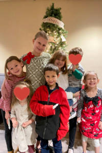 seven children in front of christmas tree