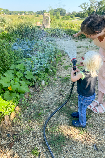 Megan and little boy water the garden