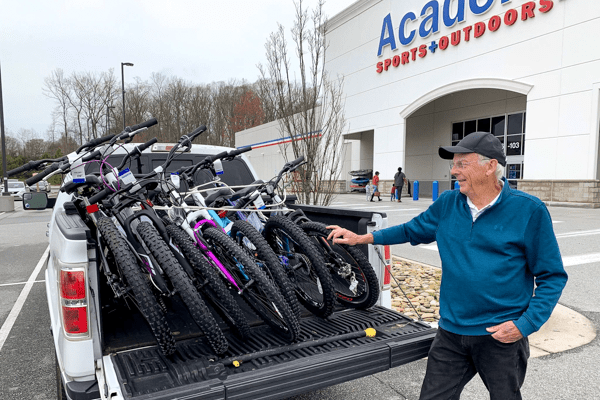 Doug Potter stands with a truck outside of Academy Sports loaded down with seven bikes to be delivered.