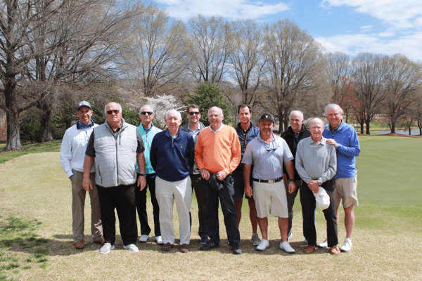 11 members of the starmount golf club pose on the green in a group, smiling