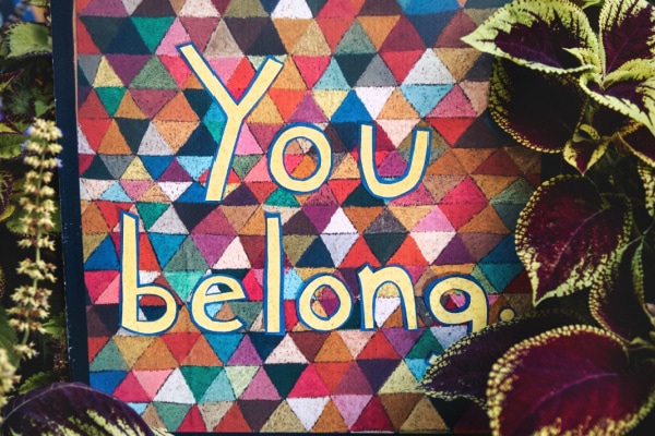 the words "you belong" painted on a triangle quilt background